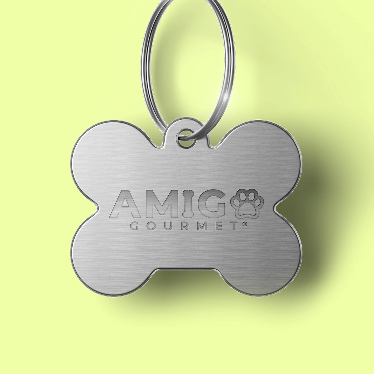 Aplicación de marca AMIGO Gourmet en placa identificadora para perros.